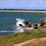 Une vague se fracasse sur un rocher.